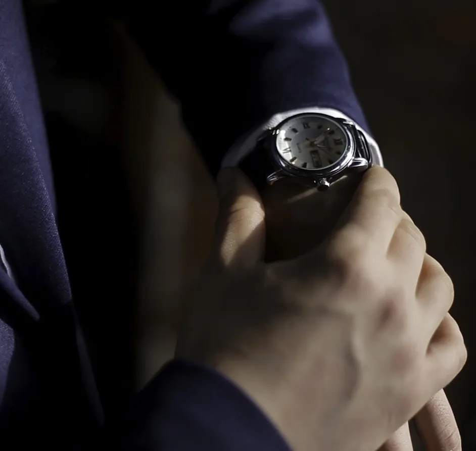 Hombre de traje ajustando su reloj