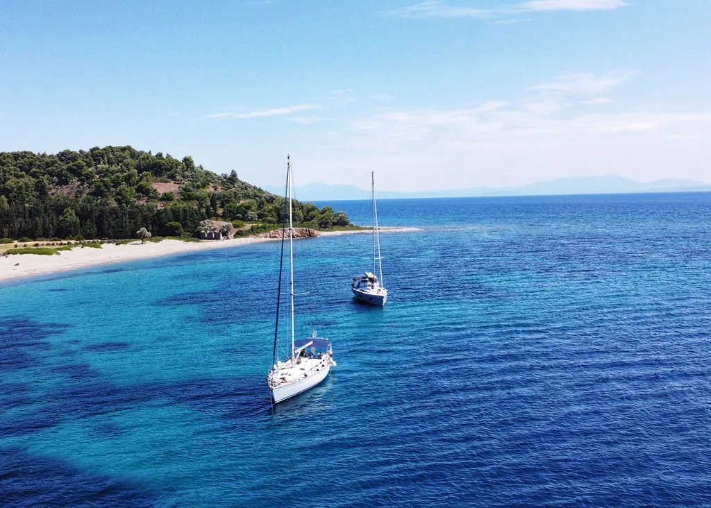Velero anclado frente a una isla de aguas turquesas